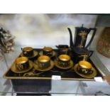 A Japanese black and gold tea set on mat