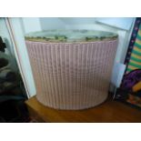 A pink Lloyd Loom laundry basket