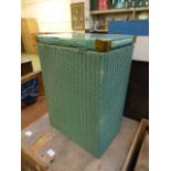 A green painted Lloyd Loom laundry baske