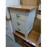 An ivory painted three drawer bedside ch