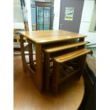 A nest of three teak veneered occasional