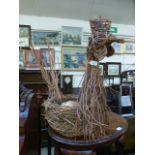 A willow woven basket in the form of a c