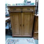 a waxed pine cabinet having a large draw