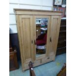 A French waxed pine wardrobe having a mi