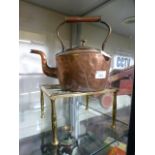 A copper kettle on a brass trivet