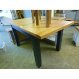 An oak topped extending dinning table with dark grey base (26.