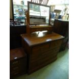 An Edwardian walnut dressing chest, the bevelled plate over trinket drawers,