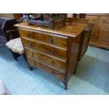 An early 20th century walnut chest of four long drawers