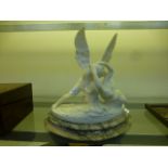 An alabaster carved figure of an angel and a lounging lady on a grey marble plinth