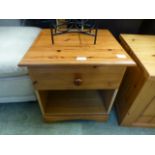 A modern pine bedside cabinet having single drawer above open storage