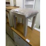 A grey stool with upholstered feet (2.