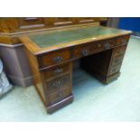 An Edwardian walnut twin pedestal desk with a tooled green leather insert to top