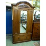 A Victorian mahogany wardrobe having a mirrored centre door with drawer to base