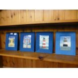 A set of four blue framed seaside prints