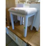 A grey based stool with upholstered seat (33.