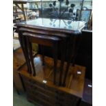 A reproduction nest of three mahogany occasional tables