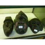 Three carved wooden Himalayan masks
