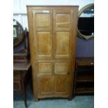 An early 20th century cabinet having twin panel doors over a single four panel door