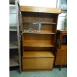 A mid-20th century design teak unit having a raised shelf unit with sliding doors