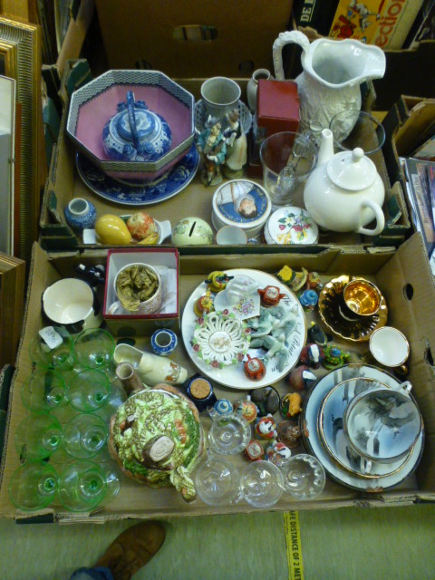 Two trays of ceramic and glassware to include water jugs, teapot figurines, plate etc.