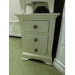 A white three drawer bedside chest (6.14/12) CONDITION REPORT: H. 56.5 cm W.