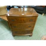 A reproduction burr walnut bow front chest of three drawers on bracket feet