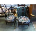 A pair of Ercol armchairs with fleur de lis design to splat