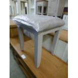 A grey stool with upholstered feet (2.