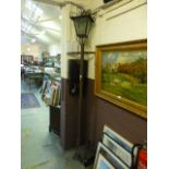 An outdoor lamp on cast iron stand with lantern top,