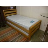 A modern single bed with pull out bed underneath and two mattresses