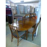 A mid 20th century teak extending dinning table by McIntosh along with a set of six matching single