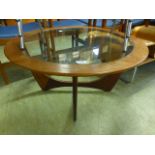 A mid-20th century teak circular topped table with glass insert to top