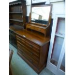 An Edwardian walnut dressing chest, the bevelled plate over trinket drawers,