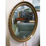 A gilt framed oval mirror