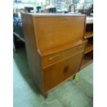 A mid-20th century teak bureau having pull down flap above drawer and cupboard doors