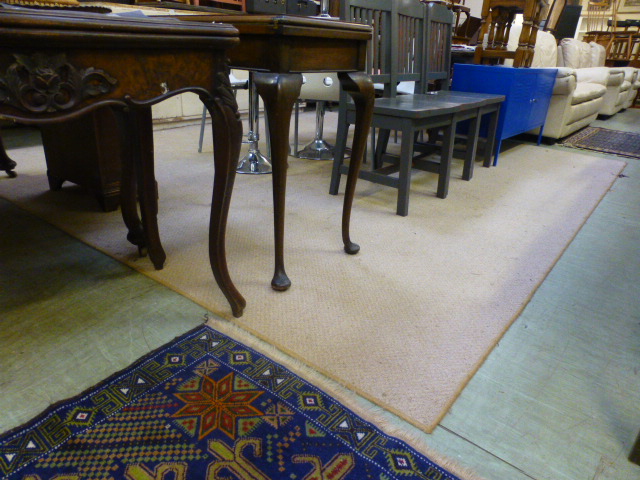 A large rectangular beige rug CONDITION REPORT: 352 cm x 300 cm Some stains,