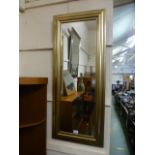 A modern gold painted rectangular wall mirror