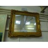 An ornate gilt framed rectangular mirror