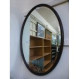 An early 20th century oak framed oval bevel glass mirror CONDITION REPORT: H.