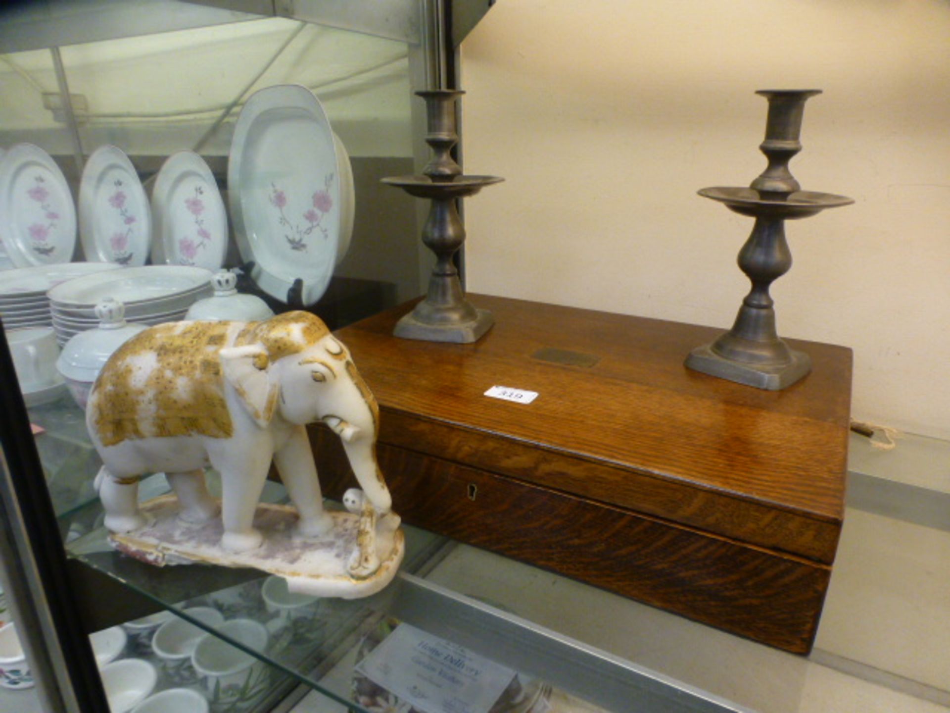 An oak canteen case together with a pair of pewter candlesticks and a carved alabaster elephant