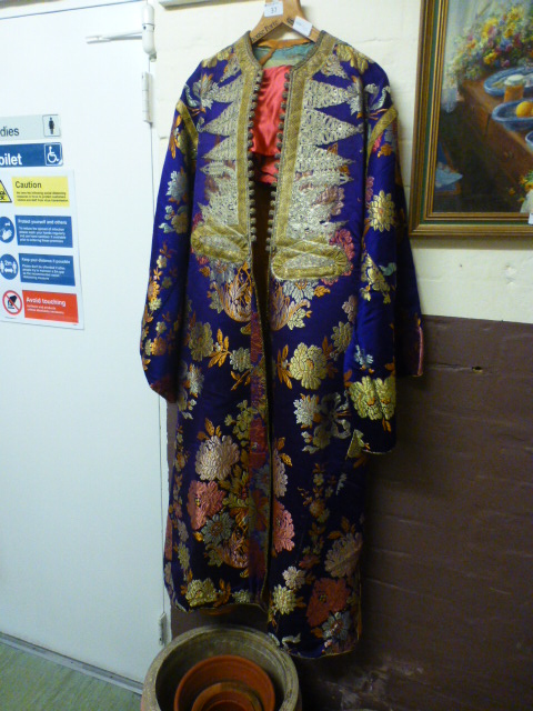 An oriental gown with floral needlework on silk along with a pink dress