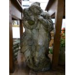 A weathered stoneware garden statue of lovers