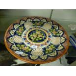 A hand painted floral glazed clay plate