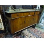 A mid-20th century laminated sideboard having three drawers above cupboard doors with pullout end