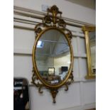 A modern ornate gilt framed oval mirror