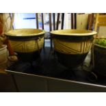 A pair of salt glazed garden pots in metal stands