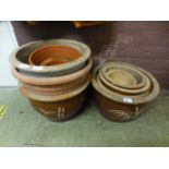 A selection of earthenware and terracotta plant pots some being glazed