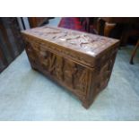 A Nigerian carved teak box depicting figures, elephants, lions etc.