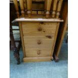 A modern pine bedside chest of three drawers