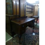 A mid 20th century mahogany desk having an assortment of drawers on cabriole feet